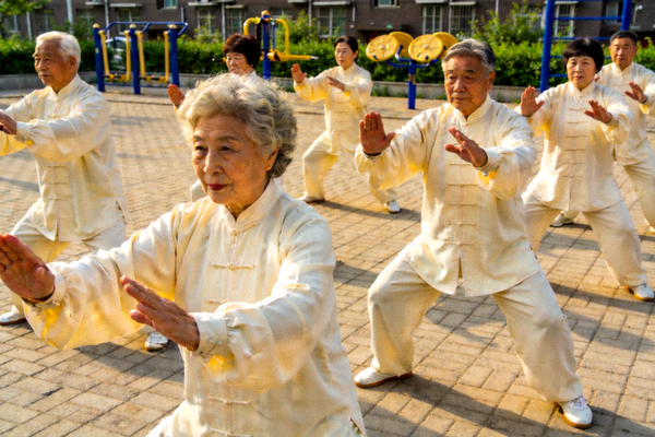 老年人在社区广场上整齐地练习太极拳