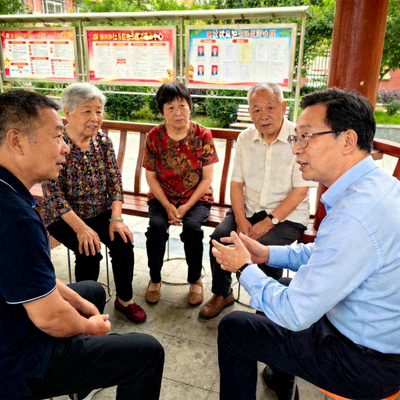 社会学专家王博士在社区活动中与居民交流