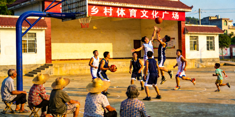 乡村体育文化广场上村民进行篮球比赛的场景