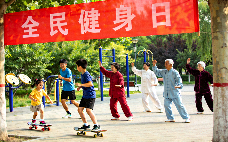 不同年龄段的社区居民齐聚一堂，在公园里共同参与全民健身日活动的欢乐场景