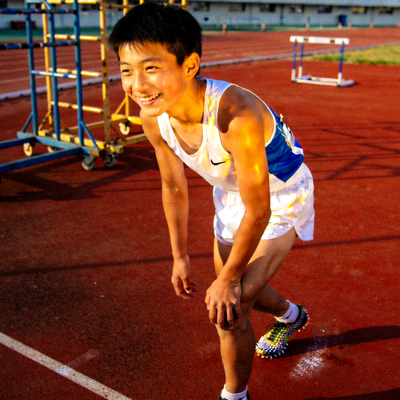 青少年短跑选手李飞在训练场上微笑