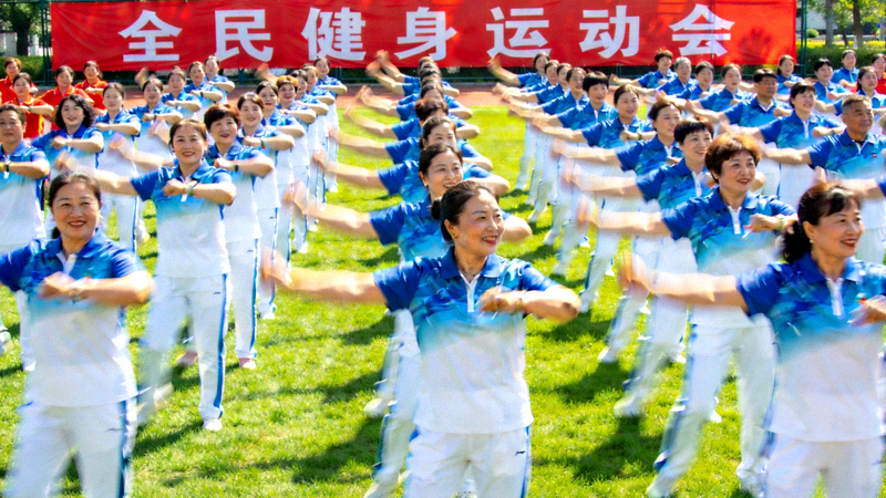 全民健身运动会现场，参与者在做集体健身操