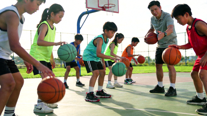 青少年在体育课上学习篮球技巧的场景